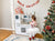 Young kid playing imaginative baking play with the kidkraft uptown white play kitchen with christimas decorations around the area